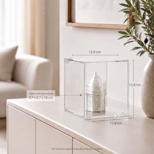 a small white miniature dome or dome-shaped object placed inside a clear glass display case on a white surface. The dimensions of the object are 5.7 x 5.7 x 10 cm, and the image is approximately 12.8 cm in width.