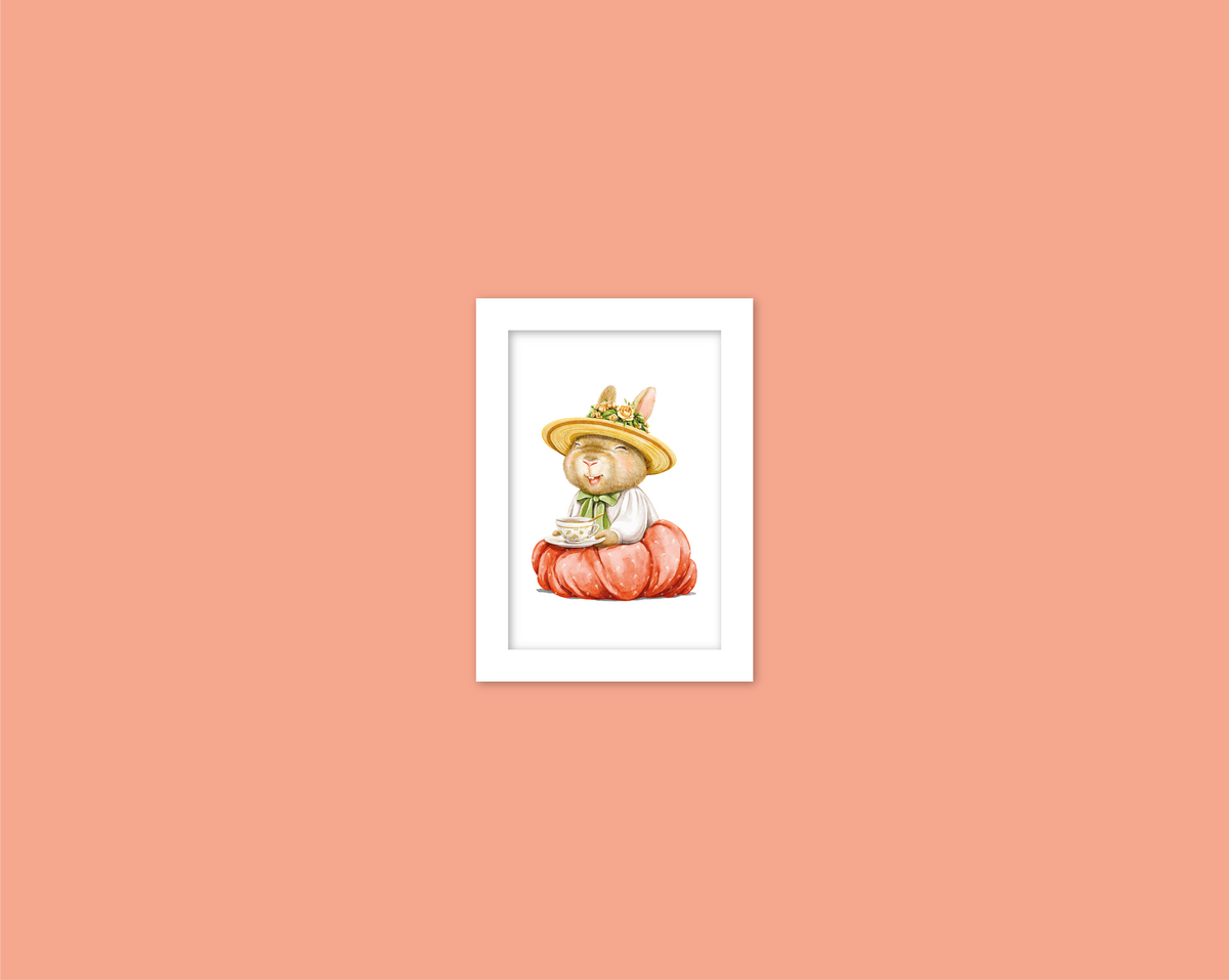 A framed illustration of a rabbit wearing a hat and sitting on a pumpkin against a peach-colored background.