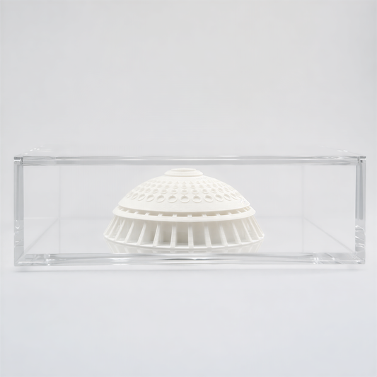 A white ceramic dome or bowl is displayed in a clear glass case against a plain white background.