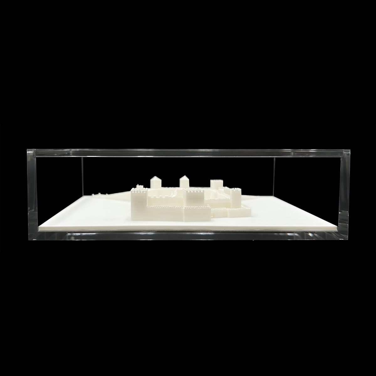 A 3D model of a building or structure displayed in a clear glass case against a black background.