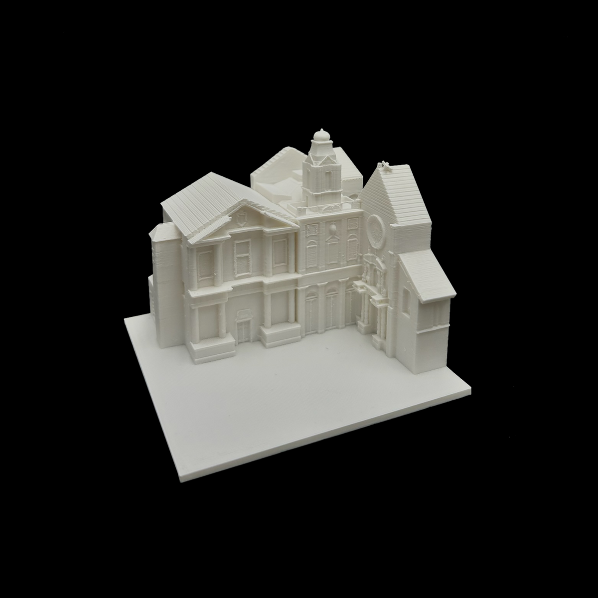 A white 3D model of a building with a tower and a clock on the front, set against a black background.