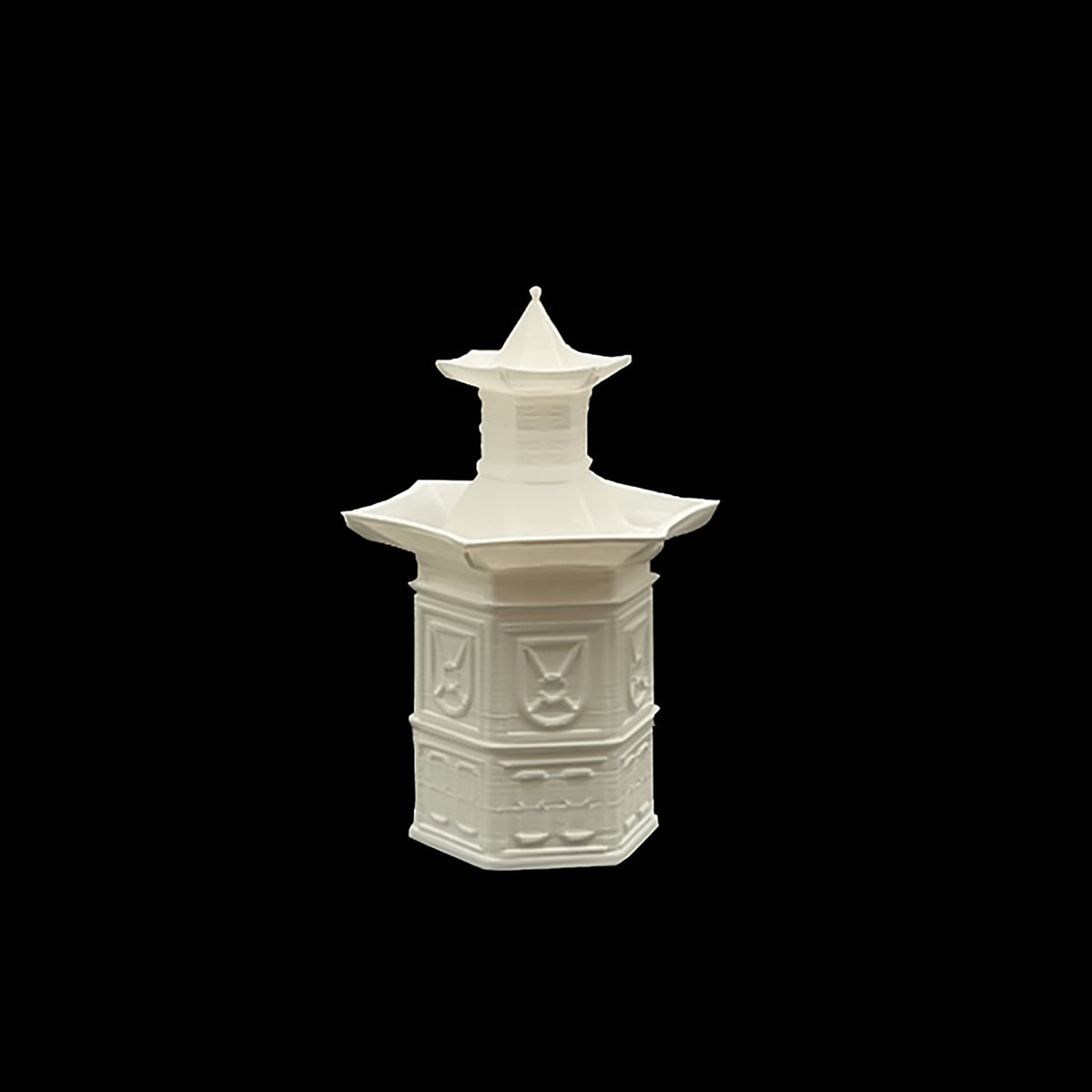 A white, ornate, and intricately designed vase or container against a black background.