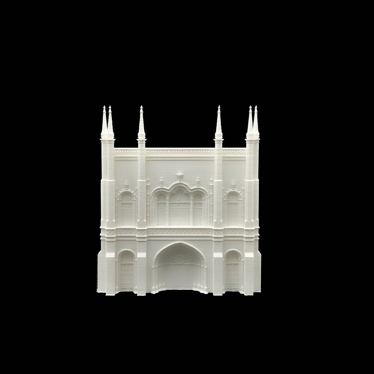 A white, three-dimensional model of a building with arched windows and spires, set against a black background.