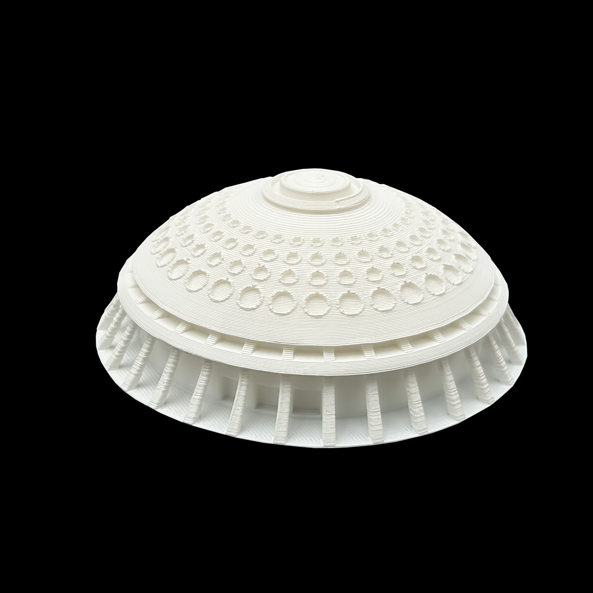 A white, dome-shaped object with a circular pattern on its surface, set against a black background.