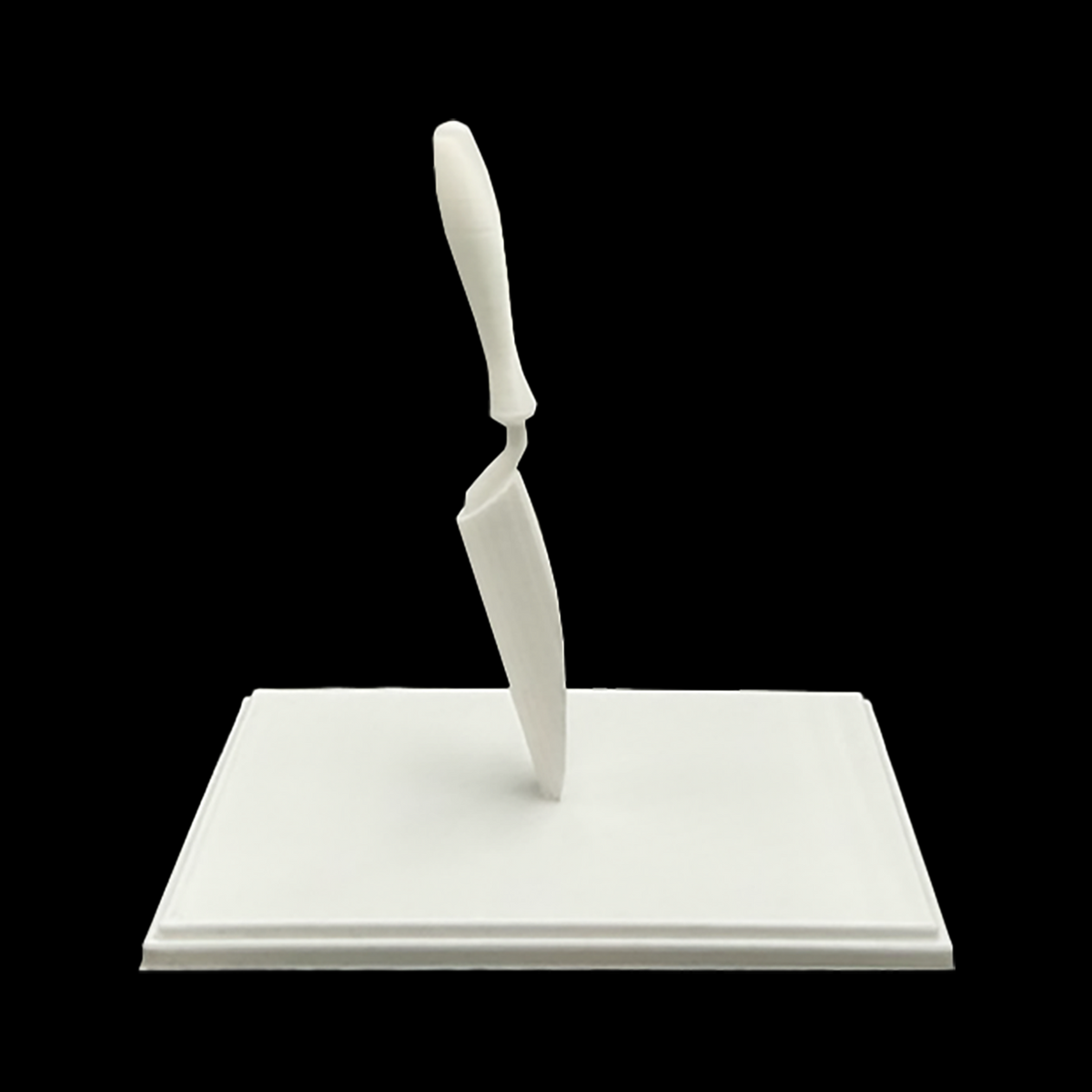 A white, three-dimensional object resembling a knife or blade is shown against a black background.