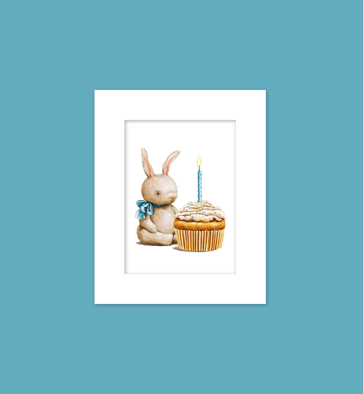 A white picture frame containing an illustration of a bunny sitting next to a cupcake with a lit candle on it.