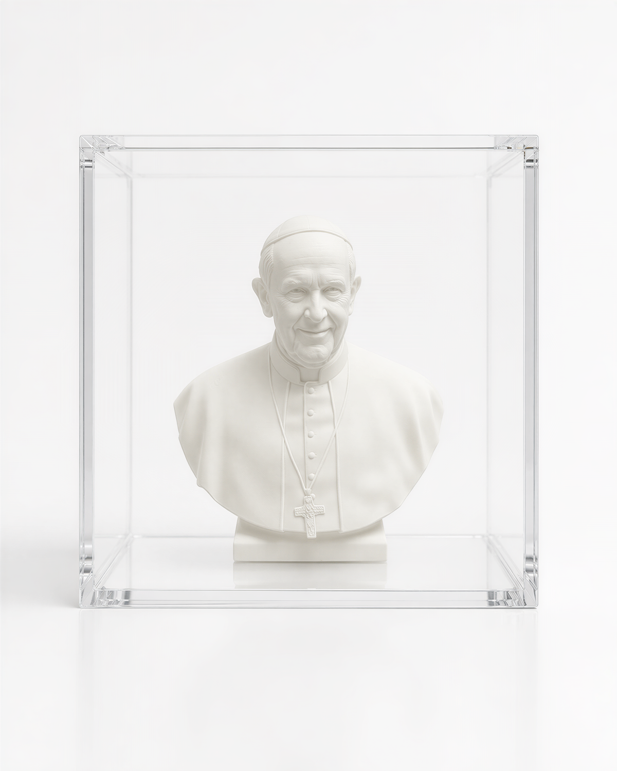 A white bust of a man wearing a religious collar, possibly the Pope, displayed in a clear glass case.