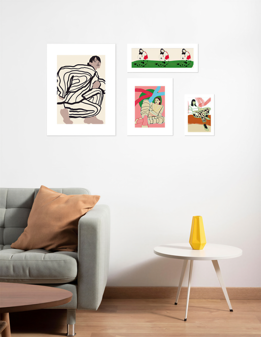 a modern living room with a gray sofa, a round coffee table, and a white wall with three framed artworks displayed above it.