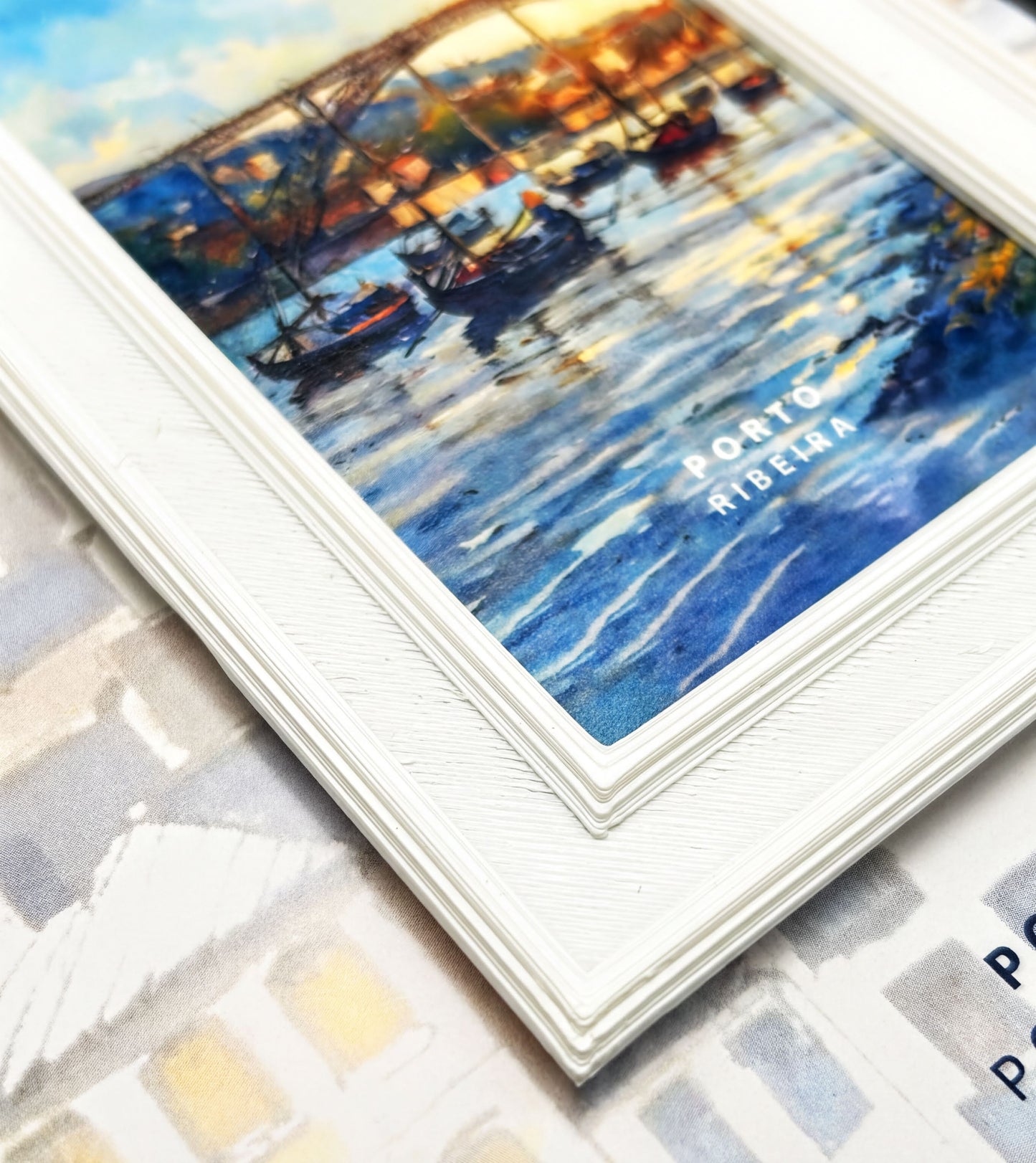 The image is a framed painting depicting a serene scene of boats on a body of water, with a bridge in the background.