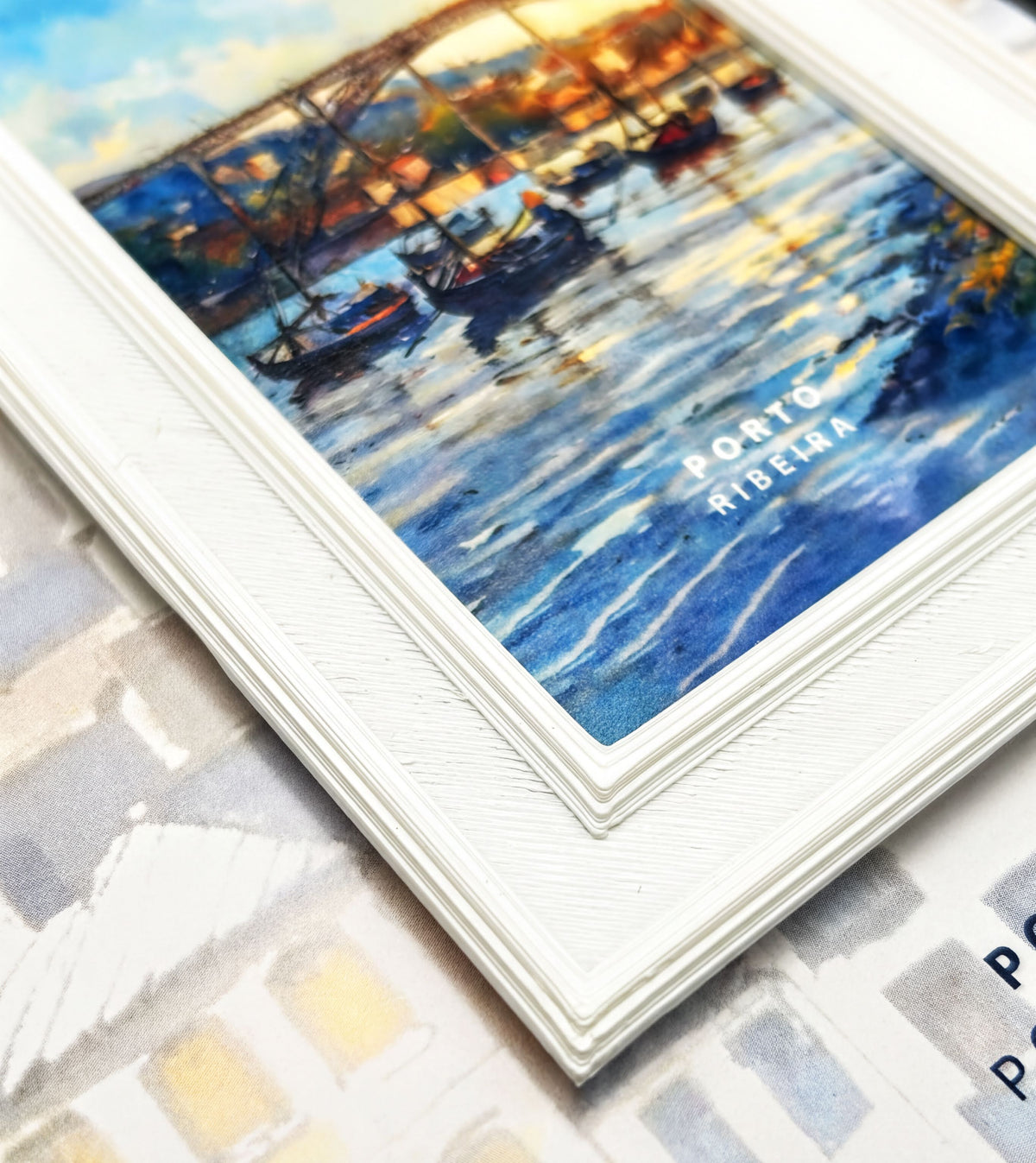 The image is a framed painting depicting a serene scene of boats on a body of water, with a bridge in the background.