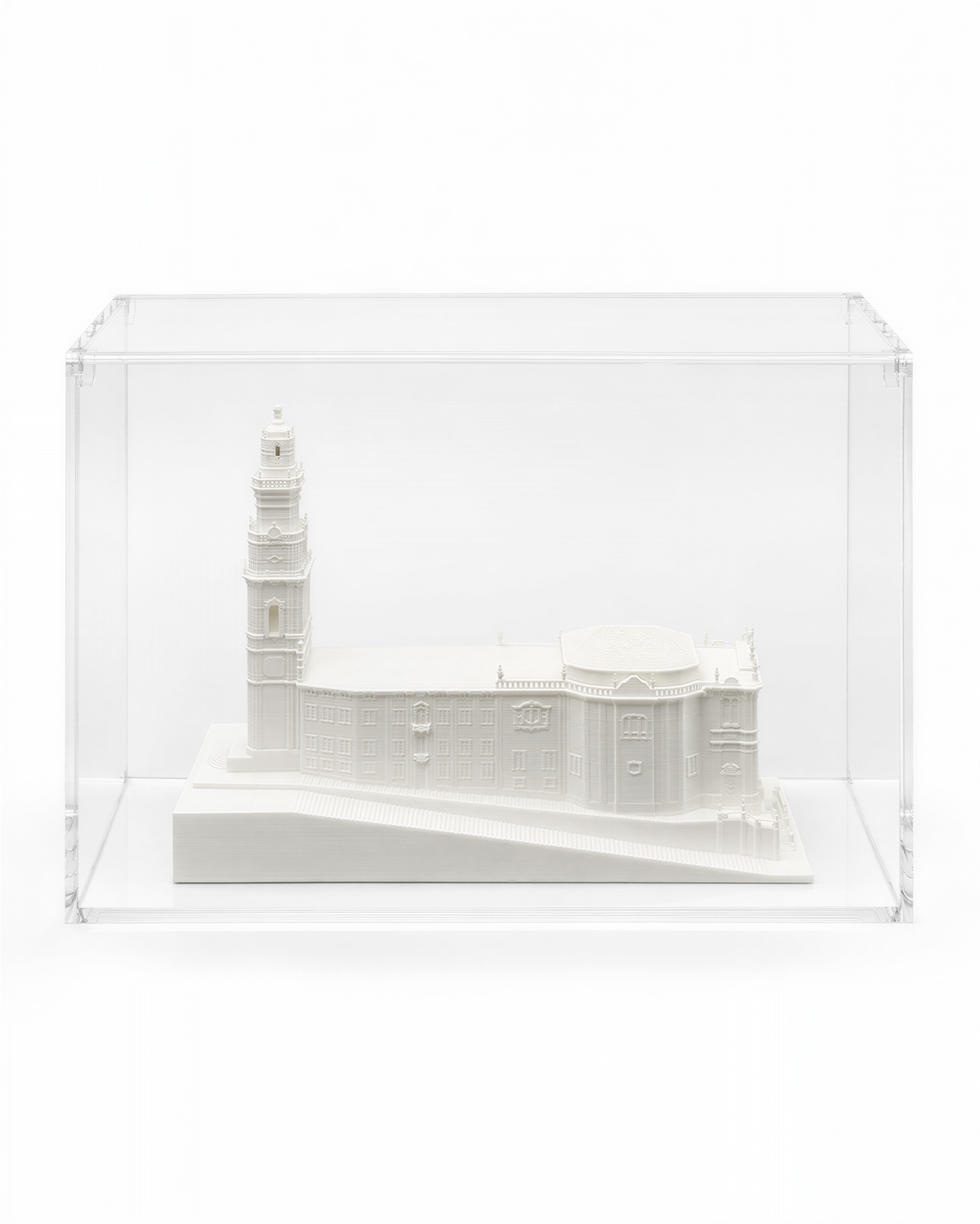 A white model of a building, possibly a church or cathedral, displayed in a clear glass case.