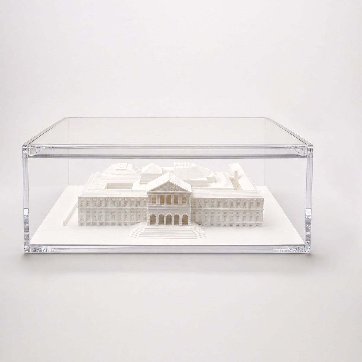 A 3D model of a building displayed in a clear glass case.