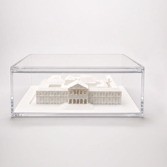 A 3D model of a building displayed in a clear glass case.