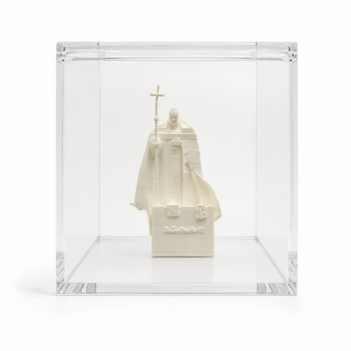 A white ceramic statue of a religious figure, possibly a saint or religious leader, displayed in a clear glass case.