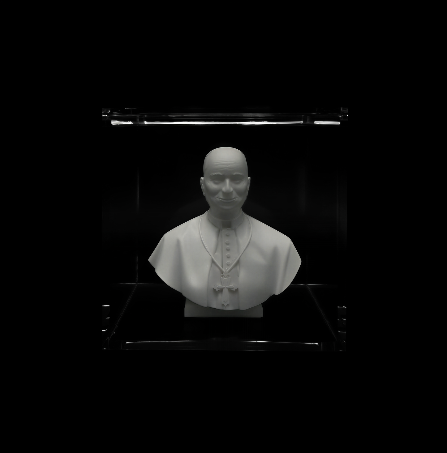 A white bust of a man wearing a white robe and a white hat, displayed in a glass case against a black background.