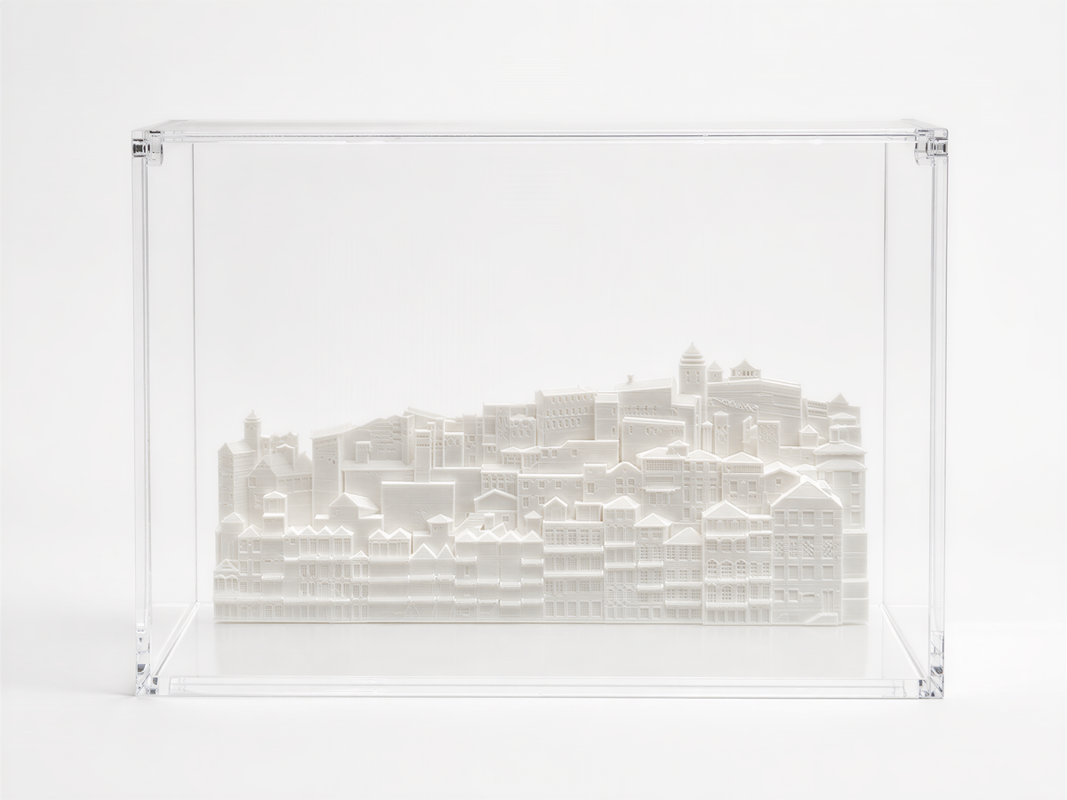 A 3D model of a cityscape displayed in a clear plastic case.