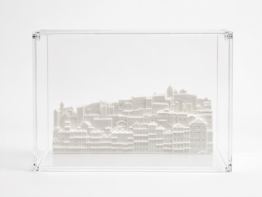 A 3D model of a cityscape displayed in a clear plastic case.