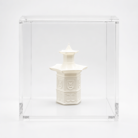 A white ceramic object, possibly a vase or sculpture, is displayed in a clear glass case against a white background.