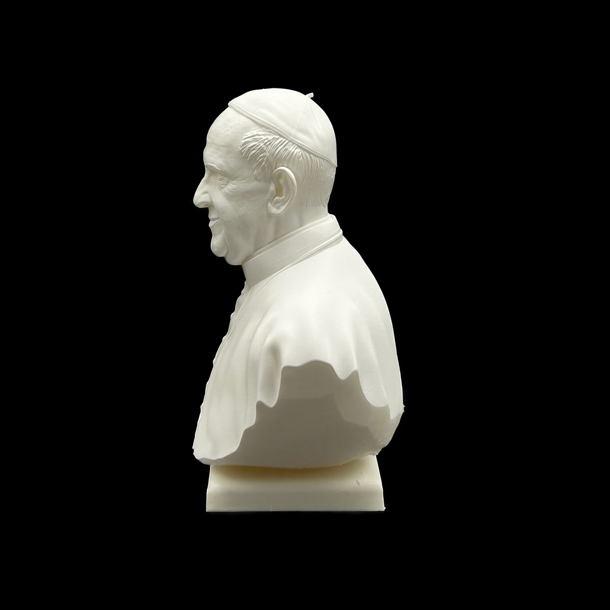 A white bust of a man wearing a hat, likely representing a religious figure, is shown against a black background.