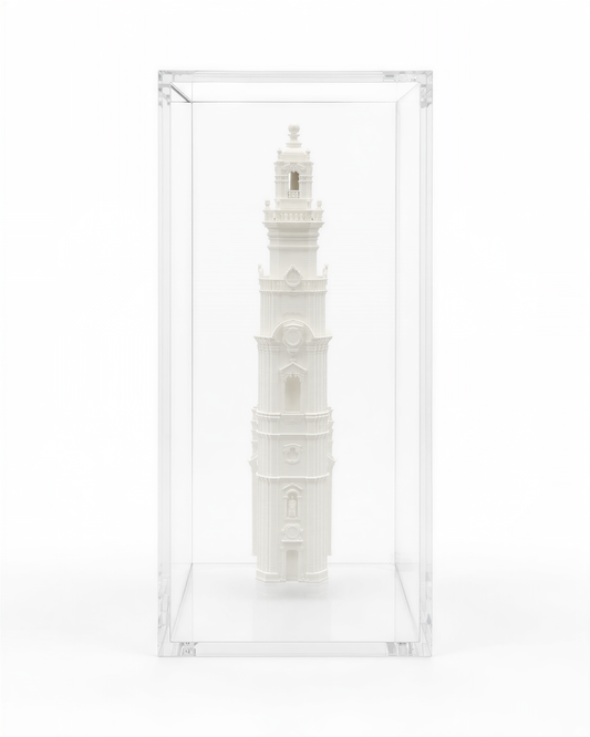A white, three-dimensional sculpture of a tall, ornate tower is displayed in a clear glass case.